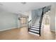 Bright living room features light wood floors, a staircase with dark railings, and lots of natural light at 1600 Gray Bark Dr, Oldsmar, FL 34677