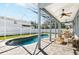 Outdoor pool area with a covered patio, ceiling fans, dining table, and comfortable seating at 1600 Gray Bark Dr, Oldsmar, FL 34677