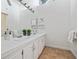 Bright bathroom with double sinks, white cabinetry, and a large mirror at 3616 W Morrison Ave, Tampa, FL 33629