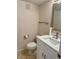 Bathroom with a toilet and sink with a framed mirror and tile flooring at 169 Medallion Blvd # E, Madeira Beach, FL 33708