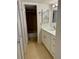 Bathroom with white vanity, mirror, and closet at 169 Medallion Blvd # E, Madeira Beach, FL 33708
