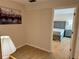 Cozy bedroom view through doorway showcases neutral walls and wood-look flooring at 169 Medallion Blvd # E, Madeira Beach, FL 33708