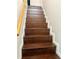 Staircase with wooden steps, white risers and banister, ascending at 169 Medallion Blvd # E, Madeira Beach, FL 33708