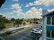 Beautiful view of the parking lot, blue skies and some palm trees from a screened lanai at 169 Medallion Blvd # E, Madeira Beach, FL 33708