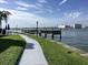 Scenic waterfront view featuring a pier, lush lawn, and the tranquil waters of the Gulf at 169 Medallion Blvd # E, Madeira Beach, FL 33708