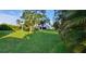 Lush backyard with a well-maintained lawn, mature trees, and glimpses of the home at 4514 Dewey Dr, New Port Richey, FL 34652
