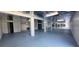 Large basement space with blue floor, white support beams, and industrial ceiling at 4514 Dewey Dr, New Port Richey, FL 34652