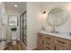 Bright bathroom featuring a marble vanity top, wooden cabinets, and a glass-enclosed shower with modern fixtures at 4514 Dewey Dr, New Port Richey, FL 34652