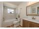 Cozy bathroom featuring a tub-shower combo with white marbled tiles and wooden cabinets at 4514 Dewey Dr, New Port Richey, FL 34652