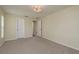 A bright, carpeted bedroom with a modern light fixture and two white doors at 4514 Dewey Dr, New Port Richey, FL 34652
