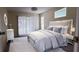 Cozy bedroom featuring soft carpet, a plush bed with neutral bedding and bright natural light from the large window at 4514 Dewey Dr, New Port Richey, FL 34652