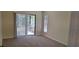 A light, carpeted bedroom with a sliding glass door that leads to a porch at 4514 Dewey Dr, New Port Richey, FL 34652