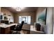 Modern office with white desk, shelving, art, and large window with bright light at 4514 Dewey Dr, New Port Richey, FL 34652