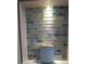 Close-up of the shower alcove showcasing the unique glass tiles and recessed lighting at 4514 Dewey Dr, New Port Richey, FL 34652