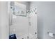 Walk-in shower featuring white subway tile with decorative blue tile accents, a glass door, and a showerhead at 4531 Swordfish Dr, Bradenton, FL 34208