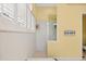 Bright bathroom with white tiled shower, yellow walls, and shuttered windows at 4531 Swordfish Dr, Bradenton, FL 34208