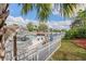 Docked boat along a canal with white picket fence and manicured lawn against a sunny sky at 4531 Swordfish Dr, Bradenton, FL 34208