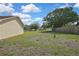 Spacious back yard featuring green grass, mature trees, and a wooden fence at 10412 Ireland St, Spring Hill, FL 34608