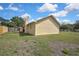 Side view of house showing stucco exterior, chimney, backyard and wooden fence at 10412 Ireland St, Spring Hill, FL 34608