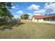 Large backyard with a wooden fence and a screen-enclosed porch, perfect for outdoor activities at 10412 Ireland St, Spring Hill, FL 34608