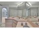 Double-sink vanity with overhead lighting and wall-to-wall mirror at 10412 Ireland St, Spring Hill, FL 34608