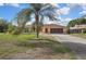 Inviting single-story home with mature palm trees, a two-car garage, and a well-kept lawn at 10412 Ireland St, Spring Hill, FL 34608