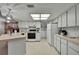 Well-lit kitchen equipped with white cabinets, appliances, and adjacent laundry area at 10412 Ireland St, Spring Hill, FL 34608