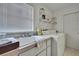 Bright laundry room with a utility sink, shelving, and a washer and dryer at 10412 Ireland St, Spring Hill, FL 34608
