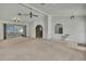 Expansive living room featuring neutral carpet, high ceilings, and access to both kitchen and screened-in lanai at 10412 Ireland St, Spring Hill, FL 34608