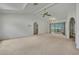 Bright living room with high ceilings, ceiling fan, neutral carpet, and access to lanai at 10412 Ireland St, Spring Hill, FL 34608
