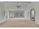 Bright and spacious living room with high ceilings, neutral carpet, and backyard views through large windows at 10412 Ireland St, Spring Hill, FL 34608