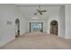 Spacious living room with arched doorways, neutral carpet, and plenty of natural light at 10412 Ireland St, Spring Hill, FL 34608