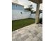 Fenced backyard with a green lawn and gray paver patio at 11594 Oak Ln, Largo, FL 33778
