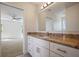 Bathroom features a vanity with granite countertop, white cabinets, and a large mirror at 11594 Oak Ln, Largo, FL 33778