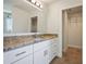 Bathroom with granite countertops, white cabinets, and a walk-in closet at 11594 Oak Ln, Largo, FL 33778