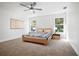 Bright bedroom with a modern ceiling fan, stylish wooden bed, and natural light from two windows at 11594 Oak Ln, Largo, FL 33778