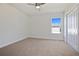 This carpeted bedroom has a ceiling fan, closet, and window overlooking the neighborhood at 11594 Oak Ln, Largo, FL 33778