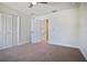 Bedroom with carpeted floor, a ceiling fan, closet, and door to the stairway at 11594 Oak Ln, Largo, FL 33778