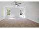 Spacious bedroom with neutral carpet, ample natural light, and a ceiling fan at 11594 Oak Ln, Largo, FL 33778
