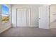 A bright carpeted bedroom with a double door closet, a window, and a doorway at 11594 Oak Ln, Largo, FL 33778