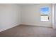 A clean, carpeted bedroom is brightly lit through a window with a view at 11594 Oak Ln, Largo, FL 33778