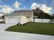 View of home, grass lawn and white fence bordering the back yard at 11594 Oak Ln, Largo, FL 33778