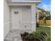 Close up of the front door entrance, with a quaint tiled walkway and manicured landscaping at 11594 Oak Ln, Largo, FL 33778