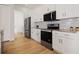 A kitchen featuring stainless steel appliances, granite countertops, and white cabinets at 11594 Oak Ln, Largo, FL 33778