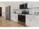 Modern kitchen features stainless steel appliances, white cabinets, granite countertops, and backsplash at 11594 Oak Ln, Largo, FL 33778