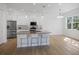 Bright, open kitchen features an island with seating, stainless steel appliances, and modern finishes at 11594 Oak Ln, Largo, FL 33778