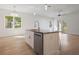 Modern kitchen island with a stainless steel dishwasher and white cabinets, complemented by pendant lighting and a spacious layout at 11594 Oak Ln, Largo, FL 33778