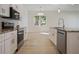 Kitchen featuring modern appliances, stone countertops, and an open view to the dining room at 11594 Oak Ln, Largo, FL 33778