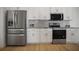 Updated kitchen featuring stainless steel refrigerator, microwave, and range plus bright, white cabinets at 11594 Oak Ln, Largo, FL 33778