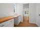 Bright laundry room with a long wooden countertop over white cabinets, offering ample space and a view into the kitchen at 11594 Oak Ln, Largo, FL 33778